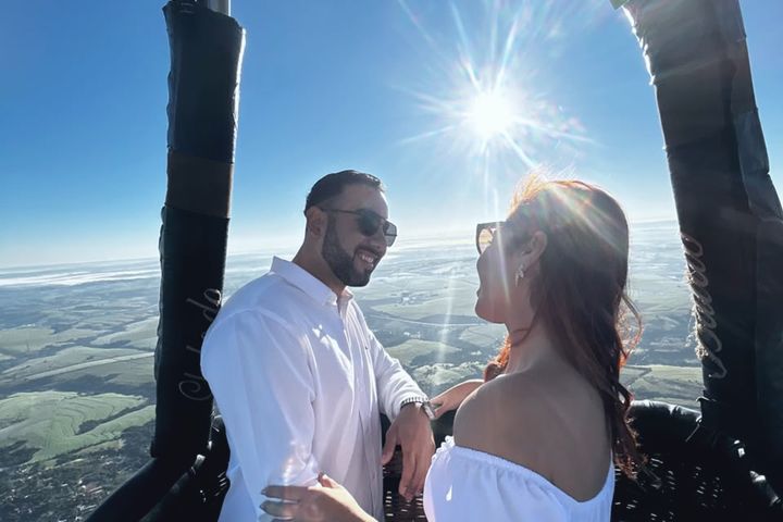 Casal abraçado no cesto com o vale de Boituva ao fundo