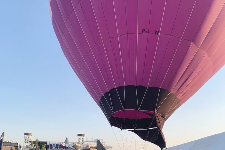 Balão publicitário montado dentro de um evento, ao lado da estrutura de palco