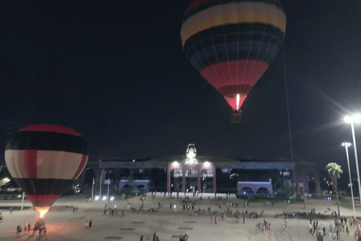 Balão iluminado à noite sobre o público de um festival